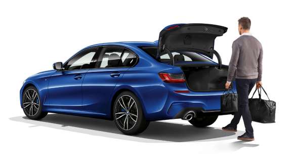 BMW Serie 3 Sedán, operación automática de la cajuela. Vista trasera de tres cuartos del BMW Serie 3 Sedán en donde el conductor abre de forma automática la cajuela con su pie.