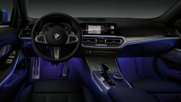 BMW Serie 3 Sedán, Luz ambiental. Vista frontal de la cabina del conductor del BMW Serie 3 Sedán con el espacio para las piernas iluminado con Luz ambiental azul.