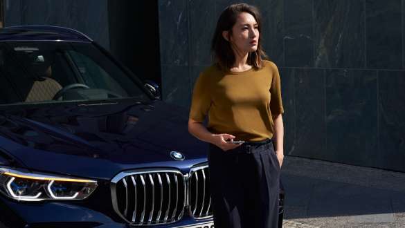 Mujer delante de BMW Asistencia en caso de avería y accidente BMW Mujer delante de BMW