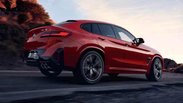 Sistema M xDrive BMW X4 M F98 LCI Renovación 2021 BMW X4 M F98 LCI Renovación 2021 Sistema M xDrive Vista de tres cuartos de la zaga circulando por una carretera