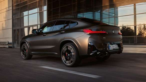 Diferencial deportivo M BMW X4 M40i M40d G02 LCI 2021 BMW X4 M40i M40d G02 LCI Renovación 2021 Diferencial deportivo M Vista de tres cuartos de la zaga delante de fachada de cristal
