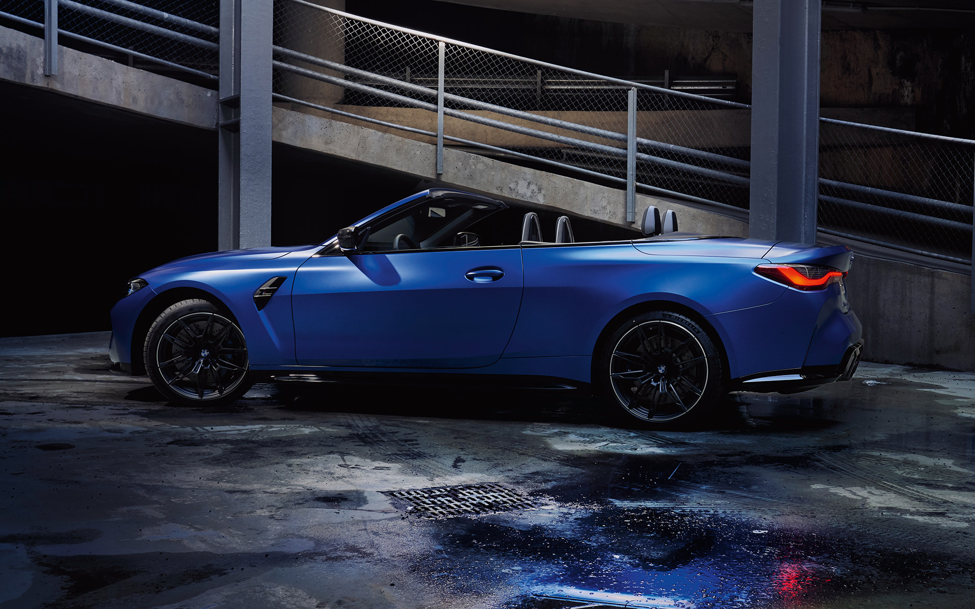 BMW M4 Competition Cabrio con sistema M xDrive G83 2021 Frozen Portimao Blau metalizado, vista lateral con capota abierta