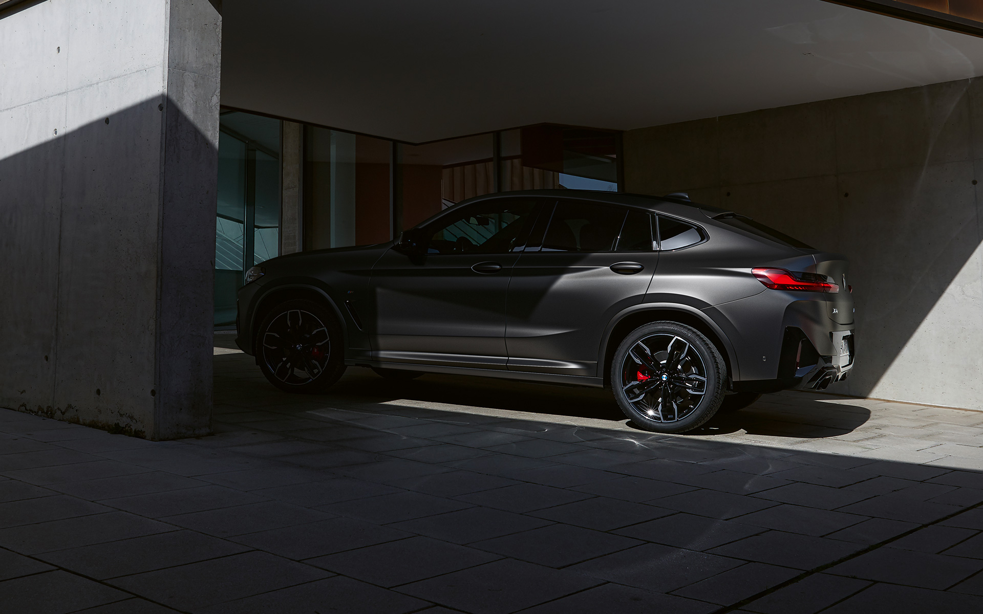 BMW X4 M40i G02 LCI Renovación 2021 Vista lateral a media sombra frente a la entrada de una casa